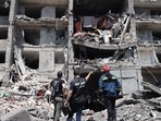 A war crimes prosecutor and a rescuer and a civil, look at a destroyed building after being hit by a missile strike in the Ukrainian town of Sergiyvka , near Odessa, &nbsp;on July 1, 2022.