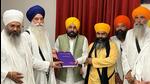 Punjab chief minister Bhagwant Mann handing over a copy of the final investigation report into the Bargari sacrilege cases in 2015 to Sikh leaders on Saturday. (HT Photo)
