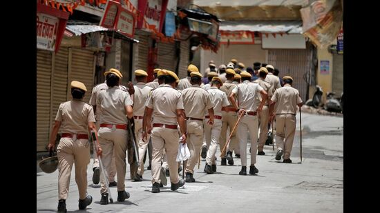 Police personnel patrol an area in Udaipur, on Saturday. (REUTERS)