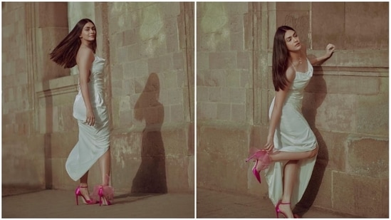 Mrunal Thakur effortlessly pulls off this chic look in an off-white satin slip dress teamed with a pair of vibrant pink stilettoes.(Instagram/@mrunalthakur)