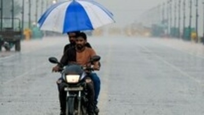 A man holds an umbrella while commuting on a bike during rainfall, in New Delhi, on July 3, 2022. (ANI Photo) A man holds an umbrella while commuting on a bike during rainfall, in New Delhi, on July 3, 2022. (ANI Photo)