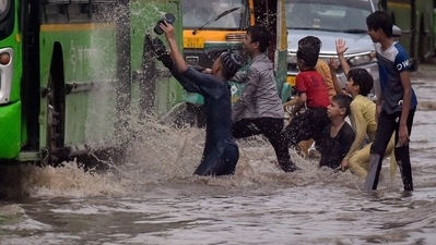 Children play as vehicles pass them by on a road waterlogged due to heavy rain, near Ramlila ground Road in New Delhi, on Sunday, July 3, 2022. (Raj K Raj/HT Photo) Children play as vehicles pass them by on a road waterlogged due to heavy rain, near Ramlila ground Road in New Delhi, on Sunday, July 3, 2022. (Raj K Raj/HT Photo)