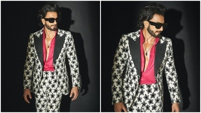 Ranveer paired the jacket with matching high-waisted pants featuring a straight-fit silhouette and black star-shaped patterns. A pink collared shirt with an open front added a pop of colour to the star's black-and-white ensemble. Additionally, he left the top buttons open to give a peek at his chiselled torso. (Instagram) Ranveer paired the jacket with matching high-waisted pants featuring a straight-fit silhouette and black star-shaped patterns. A pink collared shirt with an open front added a pop of colour to the star's black-and-white ensemble. Additionally, he left the top buttons open to give a peek at his chiselled torso. (Instagram)