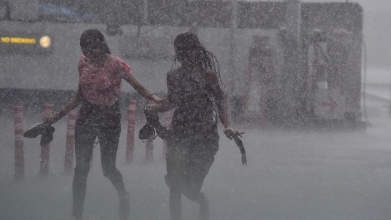 Pedestrians enjoy heavy rains outside Shivaji Metro station in New Delhi, on July 3, 2022.(Raj K Raj/HT Photo)