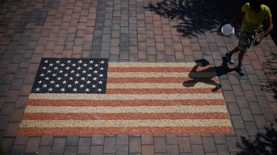 Kosovo artist Alkent Pozhegu works on the final touches of a mosaic, depicting the US flag, that he made with grain and seed to mark the US independence day in the town of Gjakova on July 4, 2022. (Photo by Armend NIMANI / AFP) / RESTRICTED TO EDITORIAL USE - MANDATORY MENTION OF THE ARTIST UPON PUBLICATION - TO ILLUSTRATE THE EVENT AS SPECIFIED IN THE CAPTION (AFP) Kosovo artist Alkent Pozhegu works on the final touches of a mosaic, depicting the US flag, that he made with grain and seed to mark the US independence day in the town of Gjakova on July 4, 2022. (Photo by Armend NIMANI / AFP) / RESTRICTED TO EDITORIAL USE - MANDATORY MENTION OF THE ARTIST UPON PUBLICATION - TO ILLUSTRATE THE EVENT AS SPECIFIED IN THE CAPTION (AFP)