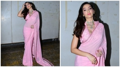 Nora teamed the saree with a matching sleeveless blouse. It has a deep V neckline, feather embellishments, cropped hem, and a multi-hued print. (HT Photo/Varinder Chawla) Nora teamed the saree with a matching sleeveless blouse. It has a deep V neckline, feather embellishments, cropped hem, and a multi-hued print. (HT Photo/Varinder Chawla)