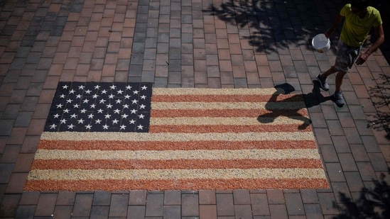Kosovo artist Alkent Pozhegu works on the final touches of a mosaic, depicting the US flag, that he made with grain and seed to mark the US independence day in the town of Gjakova on July 4, 2022. (Photo by Armend NIMANI / AFP) / RESTRICTED TO EDITORIAL USE - MANDATORY MENTION OF THE ARTIST UPON PUBLICATION - TO ILLUSTRATE THE EVENT AS SPECIFIED IN THE CAPTION(AFP)