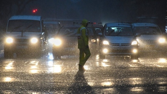 Vehicles ply on a road amid monsoon rains.(PTI)