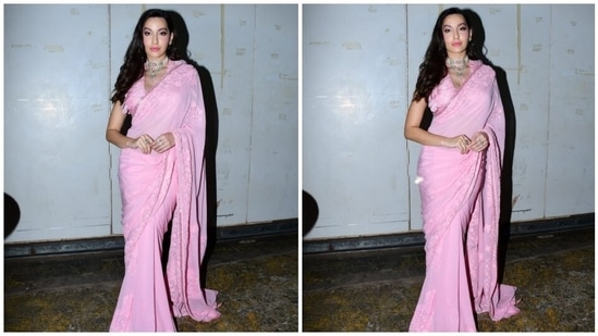 Nora draped the semi-sheer six yards in traditional style, letting the pallu drop elegantly from her shoulders. It also featured heavy embellishments and feather adornments that helped elevate the elegance quotient of the attire.(HT Photo/Varinder Chawla)