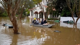 People paddle through a flooded street at Windsor on the outskirts of Sydney, Australia.