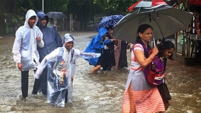 Students wearing raincoats cross a heavily waterlogged road during rainfall, at Matunga, in Mumbai. (Deepak Salvi) Students wearing raincoats cross a heavily waterlogged road during rainfall, at Matunga, in Mumbai. (Deepak Salvi)