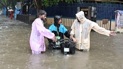 Commuters wearing raincoats move through knee-deep waterlogged streets amid rainfall. (Ashish Vaishnav) Commuters wearing raincoats move through knee-deep waterlogged streets amid rainfall. (Ashish Vaishnav)