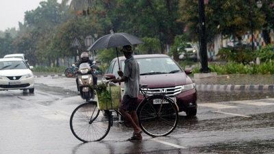  A man holding an umbrella crosses a road amid heavy rainfall, in Bhubaneswar. (Sarangadhara Bishnoi ) A man holding an umbrella crosses a road amid heavy rainfall, in Bhubaneswar. (Sarangadhara Bishnoi )