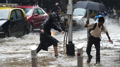 People navigate their way through a water logged street during heavy rainfall in Mumbai. (AP) People navigate their way through a water logged street during heavy rainfall in Mumbai. (AP)