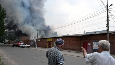 Bystanders look on as smoke rises from the central market of Sloviansk, north of Kramatosk. (AFP) Bystanders look on as smoke rises from the central market of Sloviansk, north of Kramatosk. (AFP)