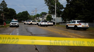 Police investigate outside the home of the mother of the man detained after the Fourth of July shooting. (REUTERS)