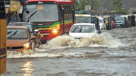 Vehicles wade through waterlogged road due to incessant rain since morning at Kurla on Tuesday. (Satish Bate/HT PHOTO)