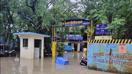 The officers attached to the Nehru Nagar police station in Kurla are wading through knee-deep water which has entered the premises on Tuesday (HT Photo)