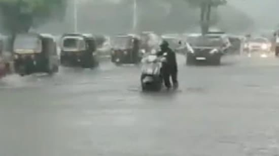 A man is forced to push his scooty manually through a waterlogged street. (ANI)