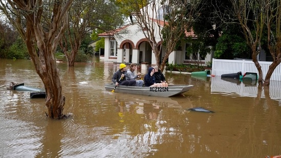 People paddle through a flooded street at Windsor on the outskirts of Sydney, Australia.(AP)