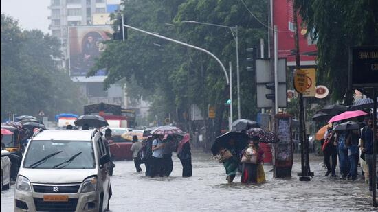 Mumbai, India - July 05, 2022 : Vehicles slow Moving and People walk in a Waterlogging on S V Road at Vile Parle West, in Mumbai, India, on Tuesday. (Vijay Bate/HT Photo)