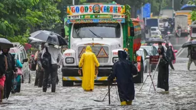 Commuters wade through a waterlogged road following monsoon rain, in Mumbai. (Agencies) Commuters wade through a waterlogged road following monsoon rain, in Mumbai. (Agencies)