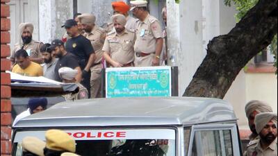 Amritsar police taking away gangster Lawrence Bishnoi (light gray T-shirt) after producing him in a local court on Wednesday. (Sameer Sehgal/HT) Amritsar police taking away gangster Lawrence Bishnoi (light gray T-shirt) after producing him in a local court on Wednesday. (Sameer Sehgal/HT)