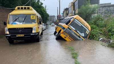 Fifteen students had a narrow escape after their school bus skidded into a waterlogged open drain in Daulat Singhwala village in Phabat area of Zirakpur. (HT Photo)