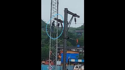 The 35-year-old man (circled) from Borivali climbing an electric tower next to an overhead wire near Kasara railway station on Wednesday. He was rescued by the locals. (HT PHOTO)