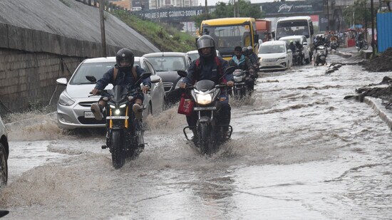 Motorists wade through water near Sai arcade, Wakad, after incessant rains lashed city on Wednesday. (HT PHOTO)