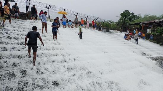 Visitors at Bhushi dam overflowing due to heavy rains, on Wednesday. Many areas of Lonavla were flooded as the city received 184 mm rainfall in the last 24 hours. (HT)