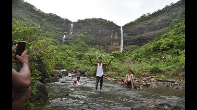 Tourists at Pandavkada waterfalls.  ₹10Cr has been allocated for developing the waterfalls by the MVA government last month. However, activists are sceptical of the funds being used for the development. (BACHCHAN KUMAR/HT PHOTO)