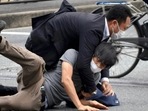 Tetsuya Yamagami, bottom, is detained near the site of gunshots in Nara Prefecture, western Japan, Friday,&nbsp;