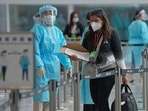Workers wearing protective gear direct arriving passengers to quarantine hotels in the Hong Kong International Airport. Hong Kong is shelving a Covid-19 measure that has resulted in dozens of cancelled flights in recent months and thwarted travel plans for thousands. (AP Photo/Kin Cheung ) Workers wearing protective gear direct arriving passengers to quarantine hotels in the Hong Kong International Airport. Hong Kong is shelving a Covid-19 measure that has resulted in dozens of cancelled flights in recent months and thwarted travel plans for thousands. (AP Photo/Kin Cheung )
