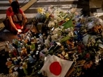 A person pays respects next to tributes laid at the site where Shinzo Abe was shot while campaigning for a parliamentary election, near Yamato-Saidaiji station in Nara.&nbsp;
