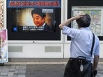 A man looks at a television broadcast showing news about the attack on former Japanese prime minister Shinzo Abe. (Photo by Charly TRIBALLEAU / AFP)