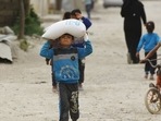 A boy carries food aid given by UN's World Food Programme in Raqqa, Syria.