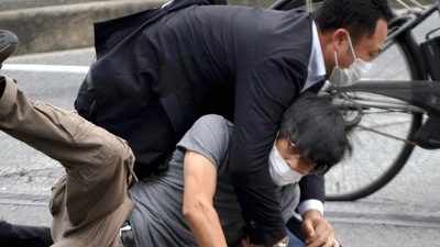 Tetsuya Yamagami, bottom, is detained near the site of gunshots in Nara Prefecture, western Japan, Friday,&nbsp; (AP)