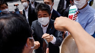 Former Japanese prime minister and ruling Liberal Democratic Party lawmaker Shinzo Abe bumps fists with voters. (Reuters / File)