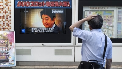 A man looks at a television broadcast showing news about the attack on former Japanese prime minister Shinzo Abe. (Photo by Charly TRIBALLEAU / AFP) (AFP) A man looks at a television broadcast showing news about the attack on former Japanese prime minister Shinzo Abe. (Photo by Charly TRIBALLEAU / AFP) (AFP)