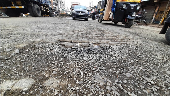 The Kamwari River Bridge road in Bhiwandi with potholes following a spell of rain over the last two days. (PRAFUL GANGURDE/HT PHOTO)