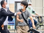 Tetsuya Yamagami, center, holding a weapon, is detained near the site of gunshots in Nara, western Japan Friday, July 8, 2022 .(Nara Shimbun/Kyodo News via AP)