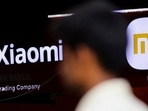 A man walks past a logo of Xiaomi, a Chinese manufacturer of consumer electronics, outside a shop in Mumbai.&nbsp;