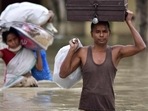Villagers wade through flood waters carrying household items at Koliabor village in the northeastern state of Assam. (File image) Villagers wade through flood waters carrying household items at Koliabor village in the northeastern state of Assam. (File image)