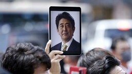 Um participante segura um tablet exibindo uma fotografia do ex-primeiro-ministro japonês Shinzo Abe durante um evento de campanha eleitoral em Yokohama, Japão. 