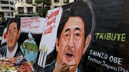 An artist applies finishing touches to a painting of late Japan's former Prime Minister Shinzo Abe.