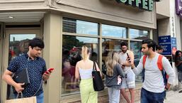 As pessoas se aglomeram em torno de um café Starbucks para usar seu wi-fi gratuito na rede Bell, durante uma grande interrupção das redes móveis e de internet da Rogers Communications, que causou interrupções generalizadas em todo o Canadá, em Toronto, Ontário, Canadá.  (REUTERS)