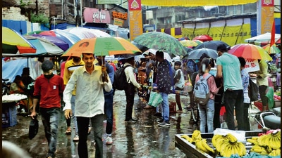 Rains did not deter people from using umbrella and visit Mandai marketplace, on Saturday. (HT PHOTO)