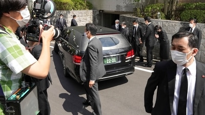 A car which is believed to carry the body of former Prime Minister Shinzo Abe, arrives at his home. (AP) A car which is believed to carry the body of former Prime Minister Shinzo Abe, arrives at his home. (AP)