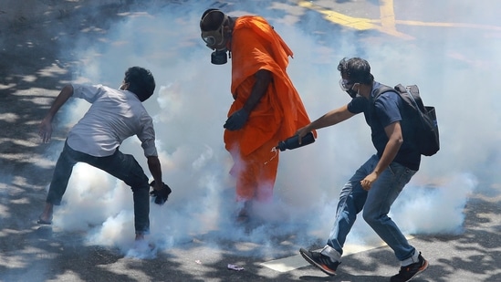 Protesters react after police fired tear gas to disperse them in Colombo, Sri Lanka, Saturday, July 9, 2022. (AP Photo/Amitha Thennakoon)(AP)